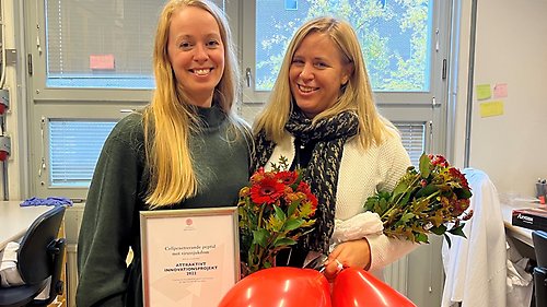 Porträttbild i labbmiljö av Anna
Överby Wernstedt och Ylva Ivarsson med diplom och blommor