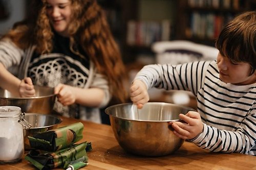 Två barn hjälper till med matlagning i ett kök