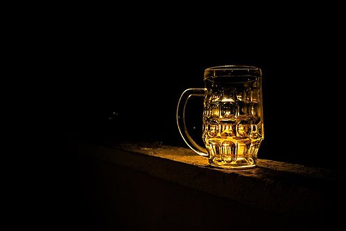 Mörk bakgrund och en sejdel med öl