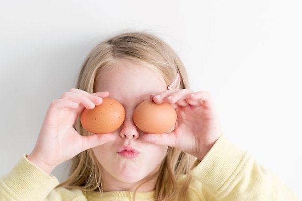 Ett barn håller upp två ägg framför sina ögon