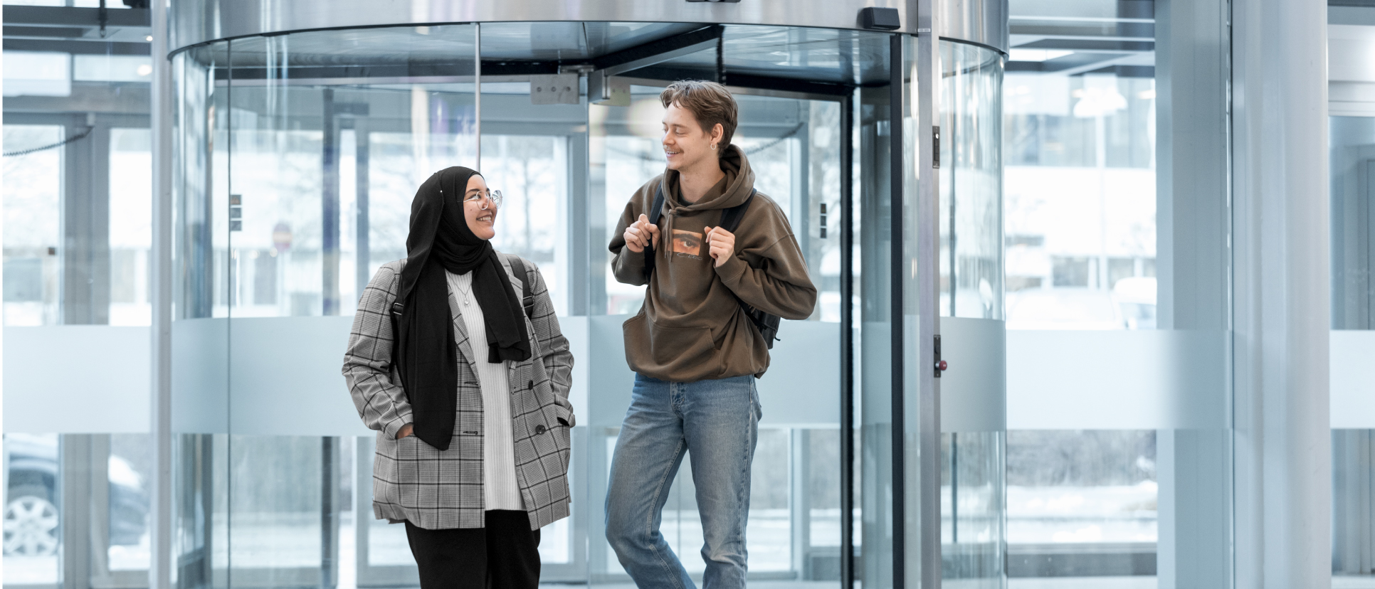 Students are smiling at the entrance to Campus Blåsenhus.