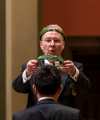 A doctoral student is crowned with a laurel wreath