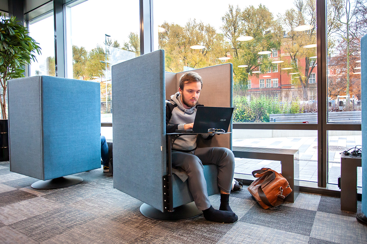 En person med laptop sitter i en fåtölj.