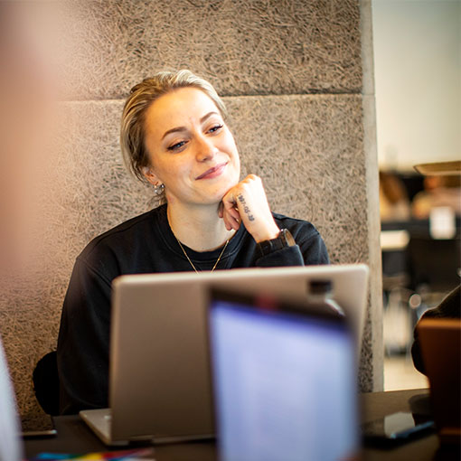 Student smiling, at laptop.