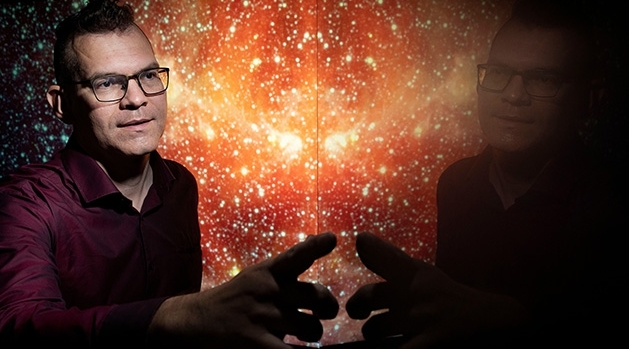 Eric Zachrisson pekar på en skärm som ser ut som en stjärnhimmel. 