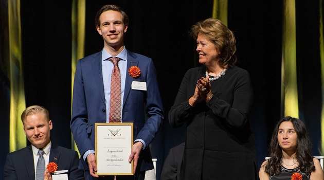 Förra årets Uppsalastudent Benjamin Verbeek får motta sitt pris av Charlotte Wall. 