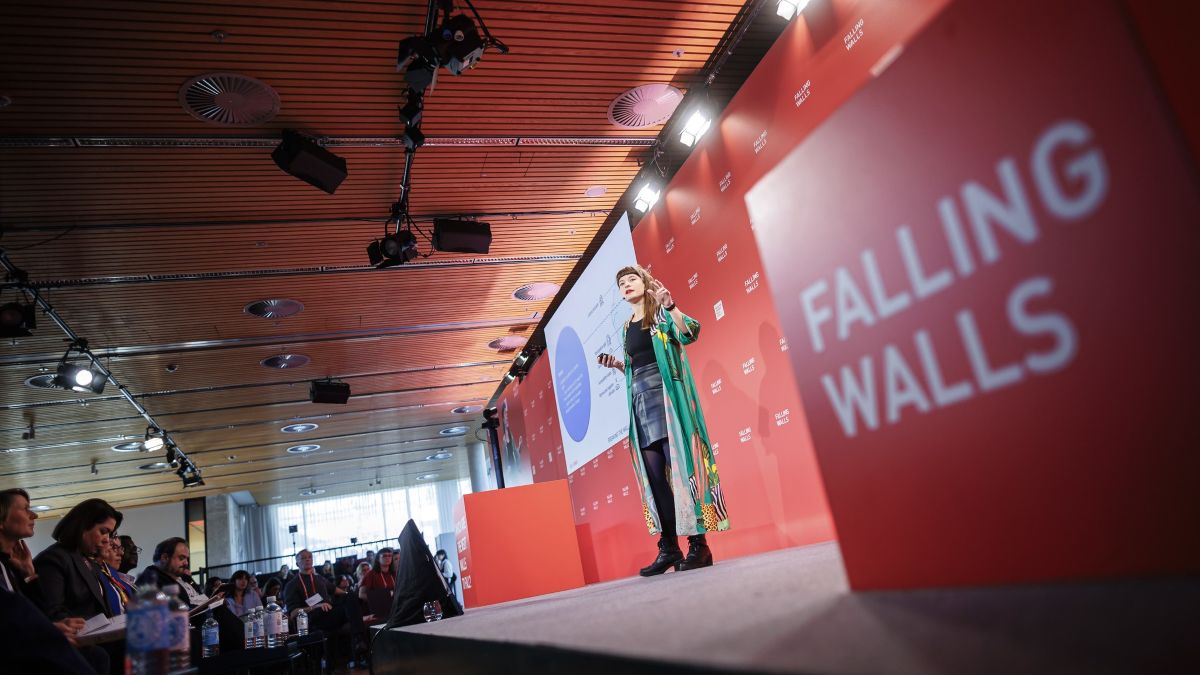 Kvinna på scen presenterar för publik på Falling Walls Lab