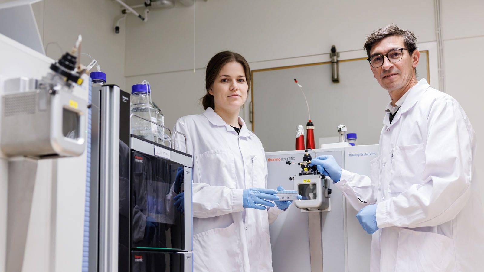 Two of the researchers behind the study, Aina Vaivane and Kim Kultima. The image also shows a mass spectrometer, which is the instrument used to measure the concentrations of PFAS and PCBs in the blood samples. Photo: Tobias Sterner/Bildbyrån