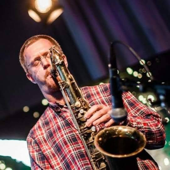 Närbild på en person (Roger Nordling) som spelar saxofon