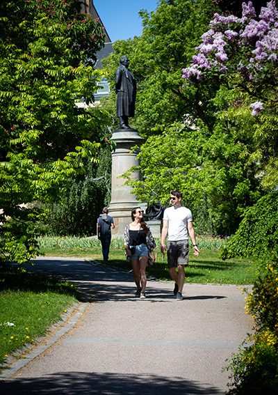 Woman and man walking in a green park.