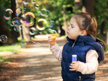 Ett barn blåser såpbubblor
