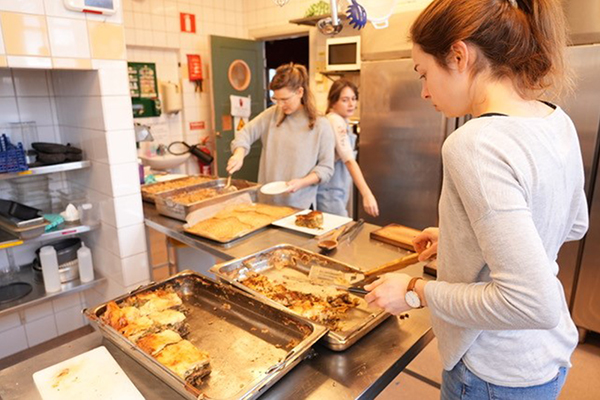 Tre studenter i köket på studentkåren Rindi. De lagar mat.
