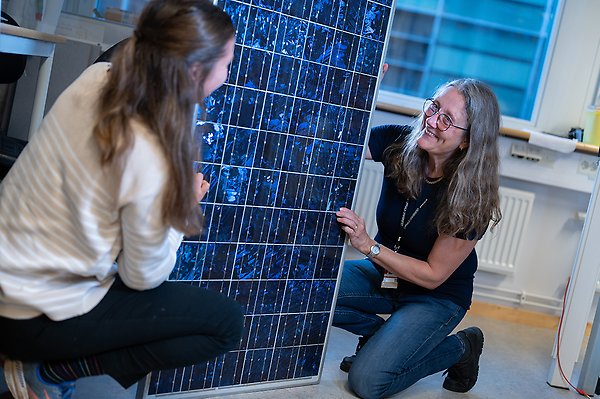 Två kvinnor som tittar på solceller