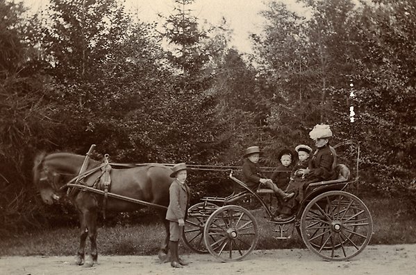 Häst och vagn med en mor och fyra barn.