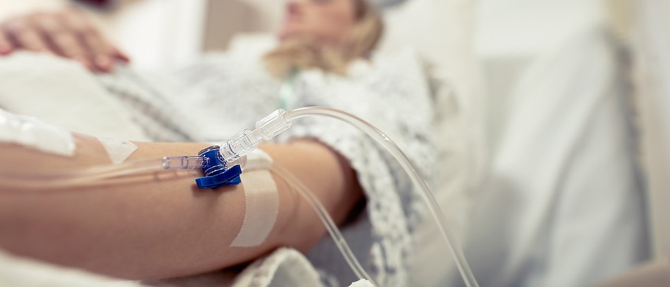 Suddig bild på en gravid kvinna i en sjukhussäng.