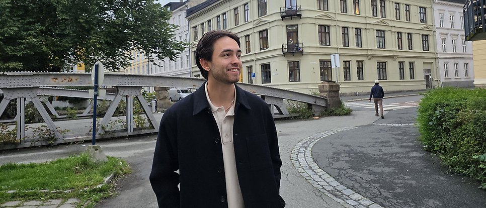 Alexander står utomhus i Oslo, i bakgrunden syns hus.