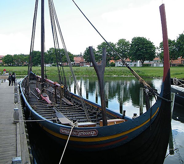 Rekonstruktion av en vikingatida båt vid en brygga