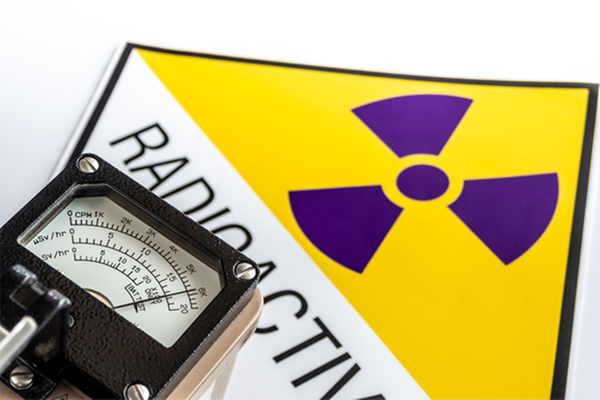 Geigermätare framför en skylt med radioaktivsymbol.