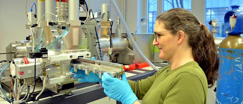 A woman loads samples into the load-lock chamber of a MICADAS-accelerator.