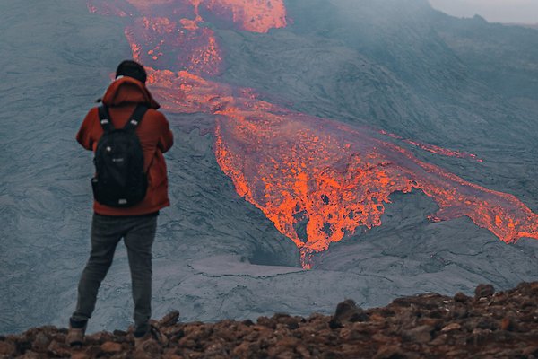 Person looking over a view of a volcanic eruption