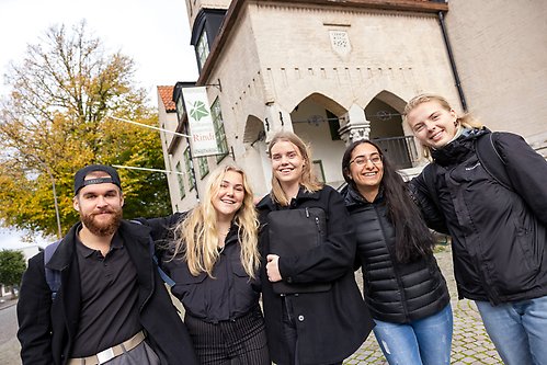Fyra studenter står utanför kårhuset i Visby och skrattar.