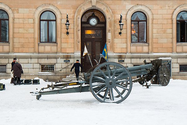 Old-fashioned cannon outside the University Main Building. Behind it there are people dressed in old military uniforms.