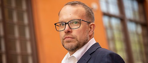 Johan Brosché utanför orange vägg och fönster