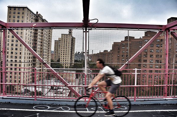 En person cyklar snabbt på en bro
