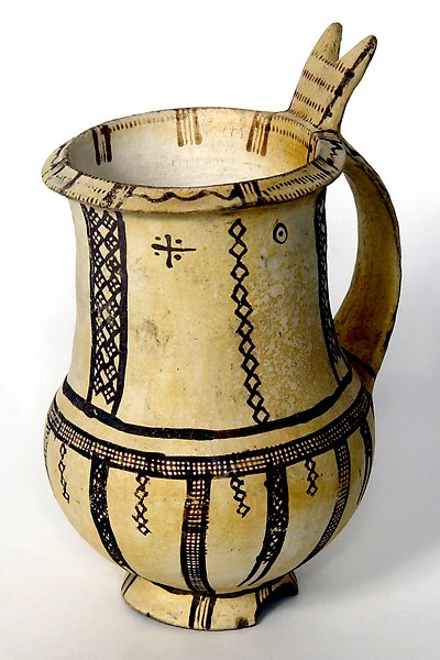 a ceramic jug with painted pattern in a dark colour.