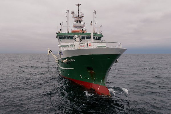A picture of a very large ship out at sea in the open ocean.