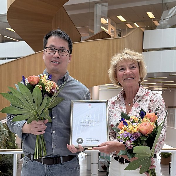 Xingqi Chen and Camilla Huse Bondesson holding flowers and diploma