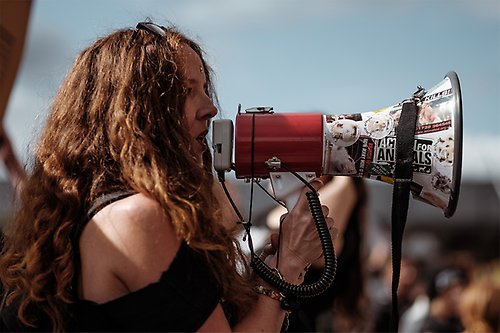 Woman at demonstration speaking in megaphone.