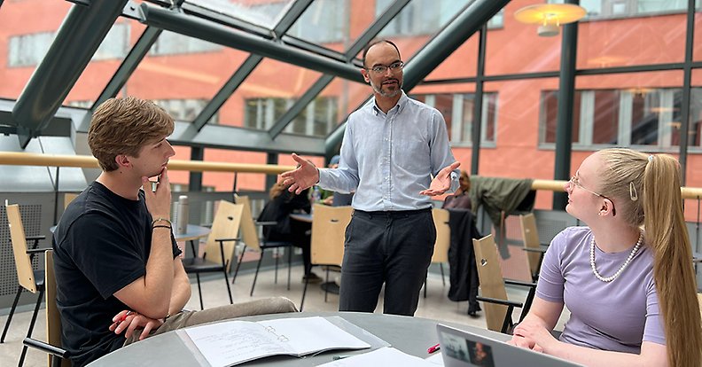 Seidon står och pratar med två studenter.