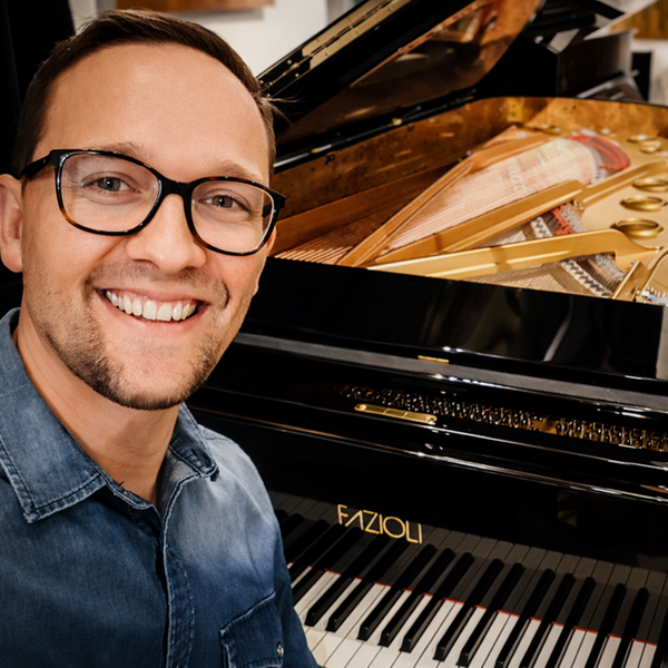 Närbild på pianisten Karl Sjölin. I bakgrunden skymtar en flygels klaviatur.