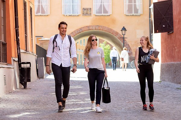 Tre studenter som går i en gränd inne i Uppsala.