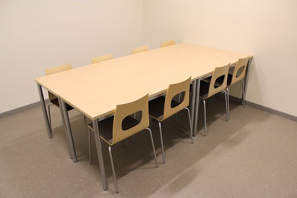 8 stolar runt ett bord i ett litet rum. / 8 chairs around a table in a small room.