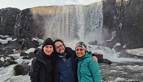 Tre personer framför ett vattenfall på Island.