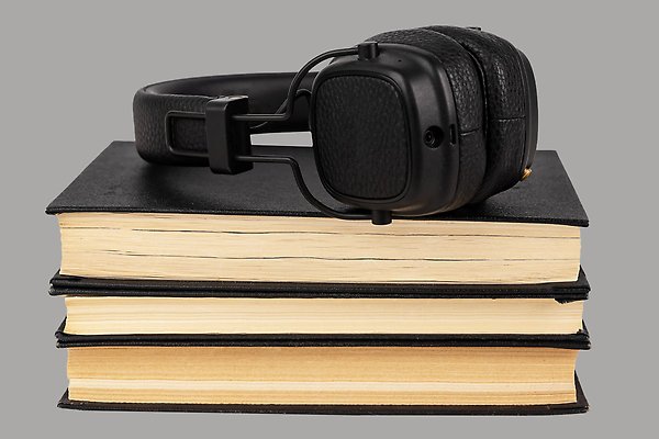 Stacked books with headphones on top.