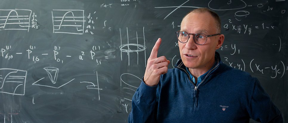Tobias Ekholm in front of a blackboard with formulas