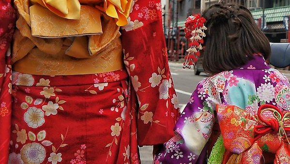 Ryggtavla av en vuxen och ett barn i traditionella japanska kläder