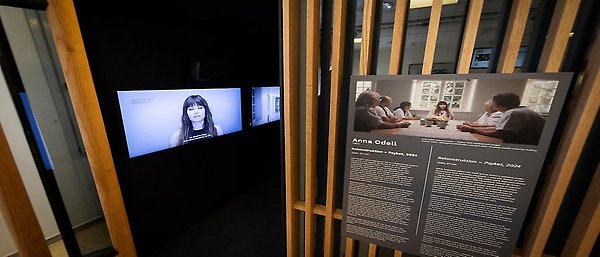Vy av mötespodd där videoverket Rekonstruktion - Psyket skymtas innanför dörren. Informationsskylt utanför dörren.  