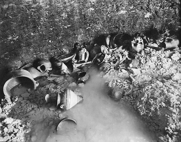 black and white picture of objects laying in water during an excavation.
