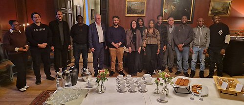 gruppbild av stipendiater vid fikabord
