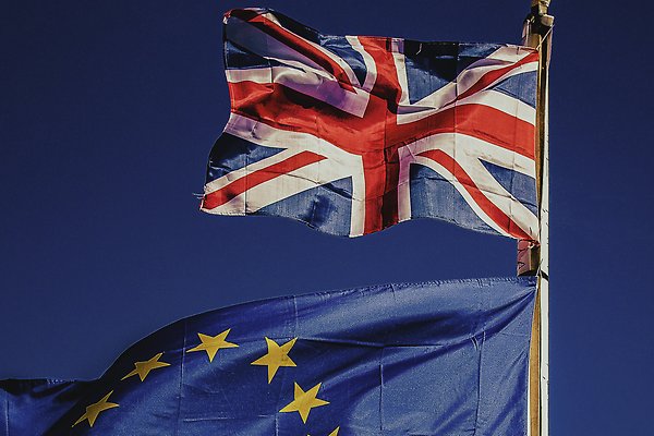 Europeiska unionens flagga och Storbritanniens flagga vajar i vinden.