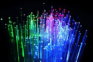 Optic fiber glowing in green, blue and purple.