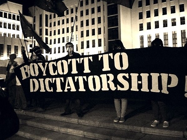 Protesters holding sign "boycott to dictatorship"