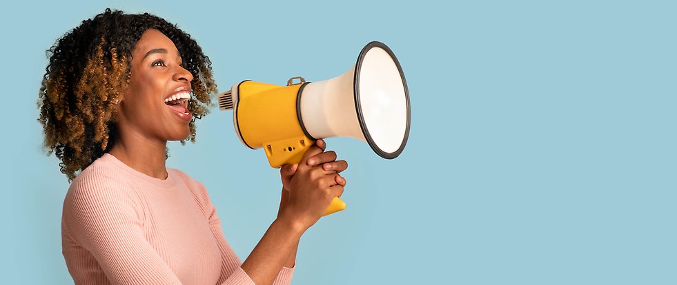 Cheerful black woman with a megaphone in hands