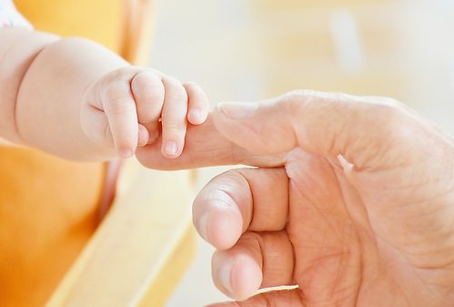 Hand som håller i en bebishand