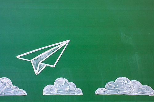 Blackboard with clouds and a paper plane.