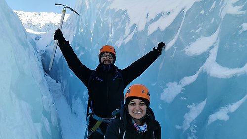 En student med en kollega på Erasmuspraktik i en glaciär i Reykjavik. Studenten håller i en yxa för att hacka is med.